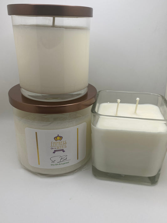 two cylindrical and one cube shaped candle jars with white candle wax