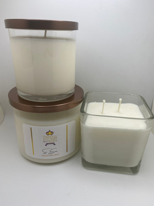 two cylindrical and one cubed shaped candle jars with white candle wax
