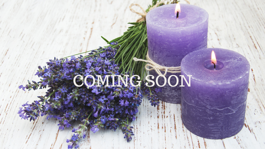Two Lit Lavender Colored Candles With Lavender Flowers Next To It And Coming Soon Heading