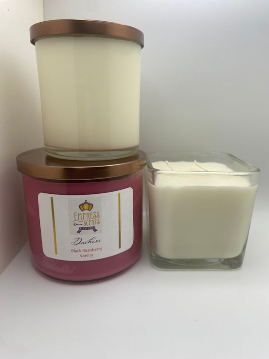 one cylindrical candle jar with white candle wax, one cylindrical candle jar with plum-colored candle wax and one cube-shaped candle jar with white candle wax