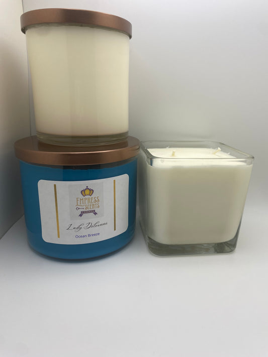 one cylindrical candle jar with white candle wax, one cylindrical candle jar with sky blue candle wax and one cube-shaped candle jar with white candle wax 