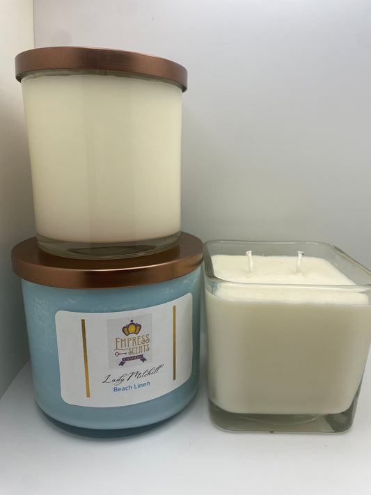 one cylindrical candle jar with white candle wax, one cylindrical candle jar with sky blue candle wax and one cube-shaped candle jar with white candle wax