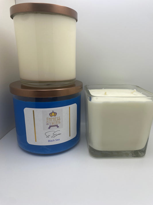 one cylindrical-shaped candle jar with white candle wax, one cylindrical-shaped candle jar with blue candle wax and one cube-shaped candle jar with white candle wax