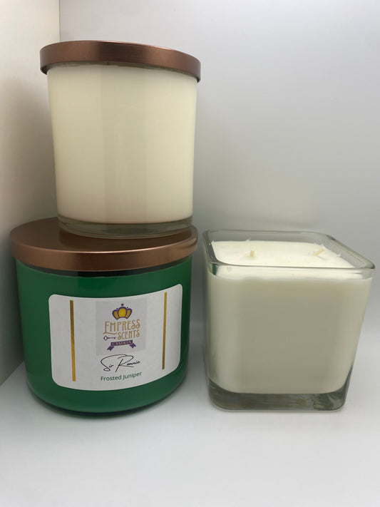 one cylindrical candle jar with white candle wax, one cylindrical candle jar with green candle wax and one cube-shaped candle jar with white candle wax