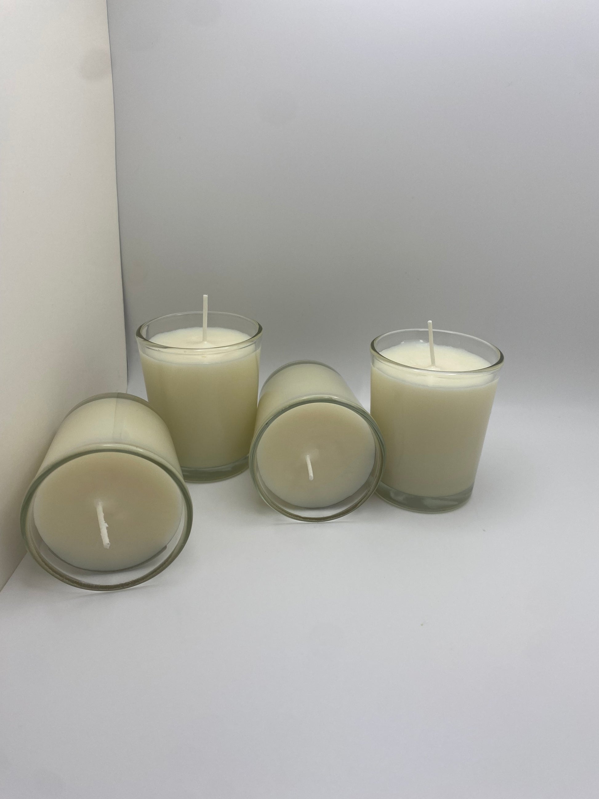 4 votive candle jars with white candle wax.